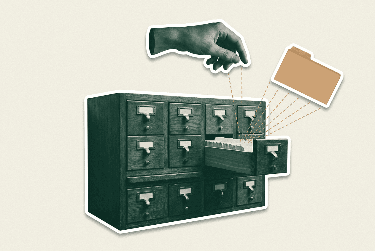 A hand lifting a tagged card from a library card-catalogue cabinet